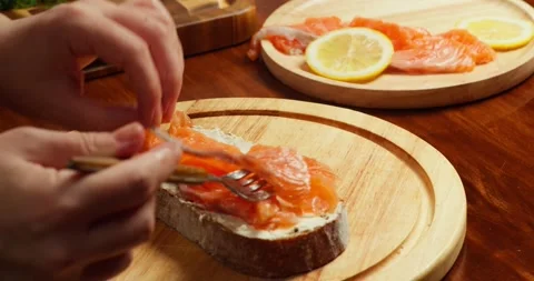 Top view Chef places slices of salted salmon on buttered bread to make an open Stock Footage 319644856