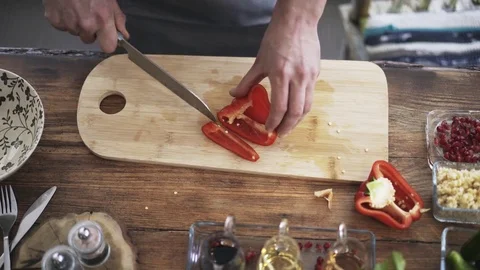 Top view of a chef slicing a red bell pepper 스톡 동영상 76590293
