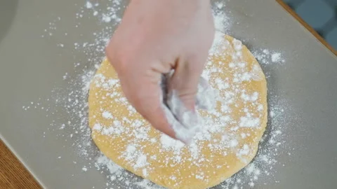 Top view: chef sprinkles flour on the round circle piece of dough in bakery. Stock Footage 133416353