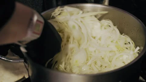 Top View of Chef Stirring Chopped Onions in Metal Pan on Stove Stockbeeldmateriaal 307089634
