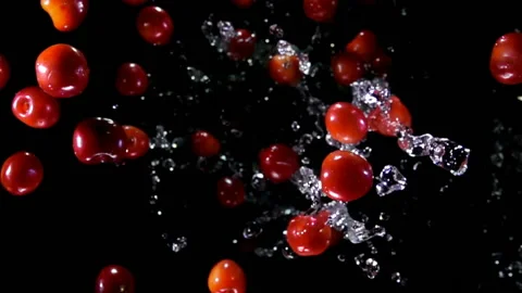 Top view of the cherries bouncing up with splashes of water on black background Video stock 146227984