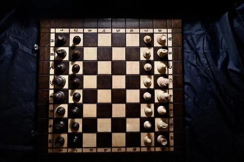 Top View of Chessboard with Black and White Pieces Set Up on Dark Background Stock Photos