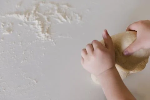 Top View of a Child Baking Bread Dough on Floured Surface 스톡 사진