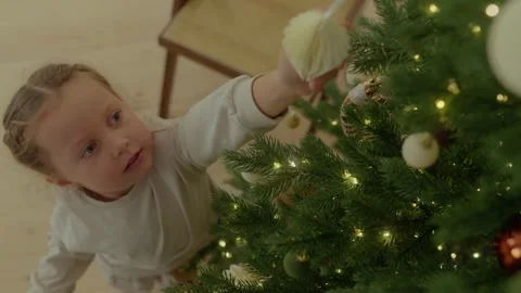 Top view, child decorating Christmas tree with toys Stock Footage 321682931