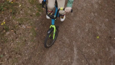 Top view of child hands on bicycle handlebar in forest Stock Footage 315757041