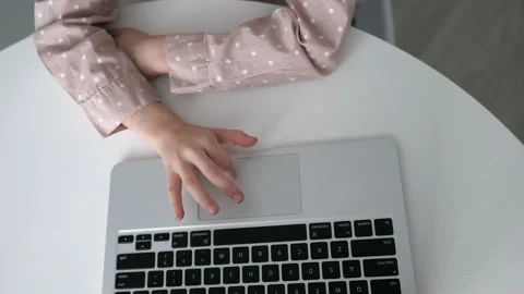 Top view child hands using the touchpad on laptop to study at home Stock Footage 234985130