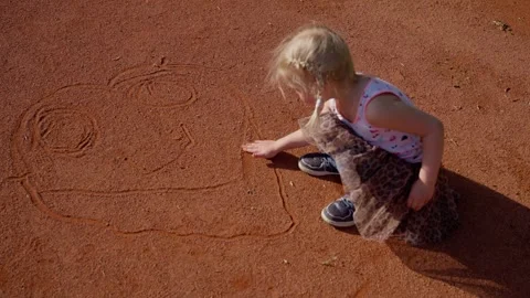 Top view. A child happily drawing outside on a sunny day, showing creativity Stock Footage 303597469