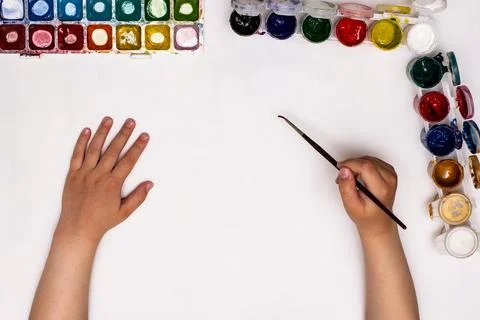Top view of children's hands while drawing gouache on paper. Stock Photos