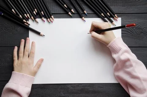 Top view of the child's hands lying on a sheet of white paper. Mockup Stock Photos