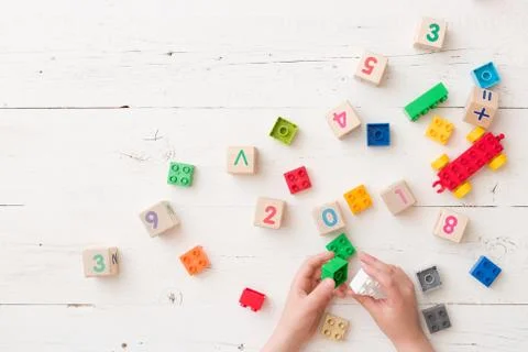 Top view on child's hands playing with wooden cubes with numbers and colorful Stock Photos
