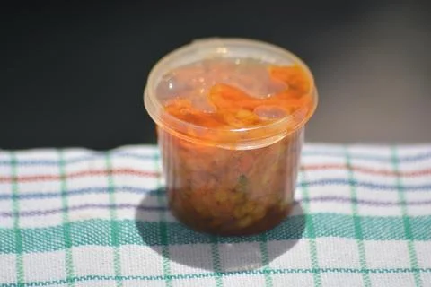 Top view chili paste in plastic container on fabric Stock Photos