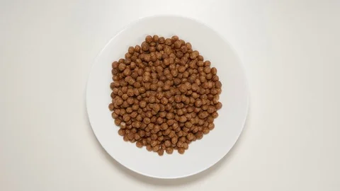 TOP VIEW: Chocolate balls fill a white dish (stop motion) Stock Footage 69809397