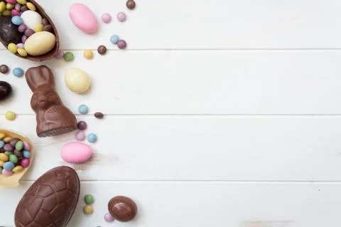 Top view of chocolate easter candies on white wooden table with copy space Stock Photos