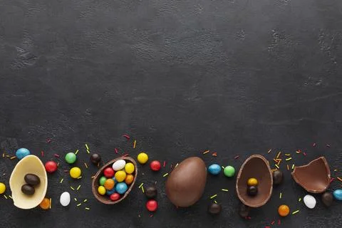 Top view chocolate easter eggs filled with colorful candy Stock Photos