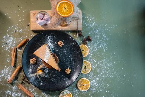 Top view of chocolate nut cake with walnut, orange and cinnamon on black plate Foto stock