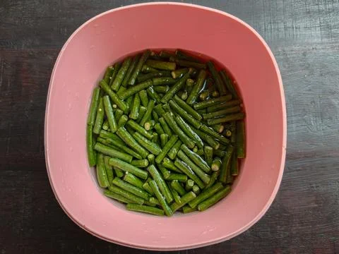 Top View of Chopped Raw Long Beans Soaking in Water Inside a Pink Plastic Bowl Photos