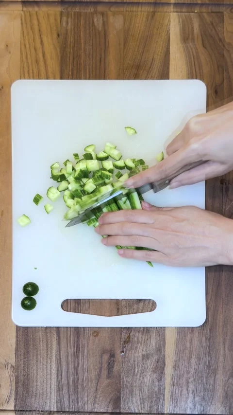 Top View of Chopping Fresh Cucumbers on Cutting Board in Kitchen-Vertical Stock Footage 333783128