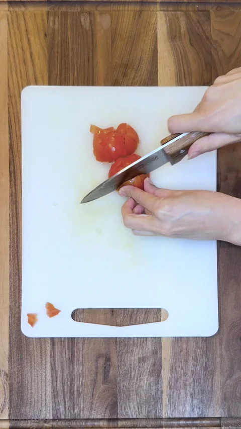 Top View of Chopping Fresh Tomatoes on White Cutting Board-Vertical Stock Footage 333784453