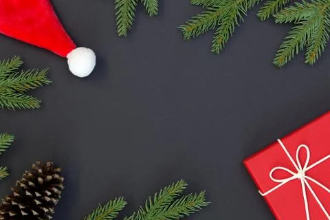 Top view of Christmas composition, gift box, pine cones, fir branches on blac Stock Photos