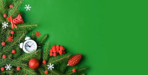 Top view Christmas composition with spruce branches and toys on green background Stock Photos