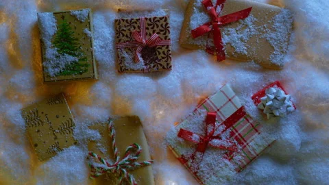 Top view Christmas gift boxes with red plaid color and ribbon wrap on snowdrifts Video stock 251598508