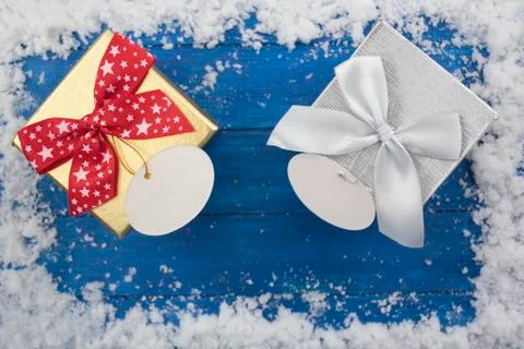 Top view of christmas gift boxes on blue wooden table with snow Stock Photos