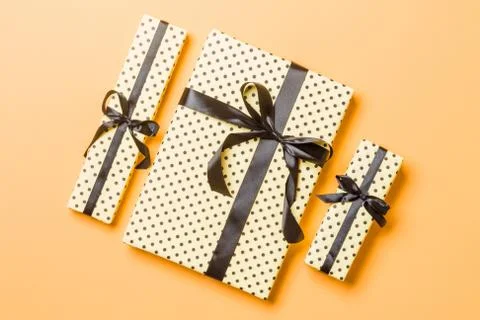 Top view Christmas present box with Black bow on orange background Stock Photos