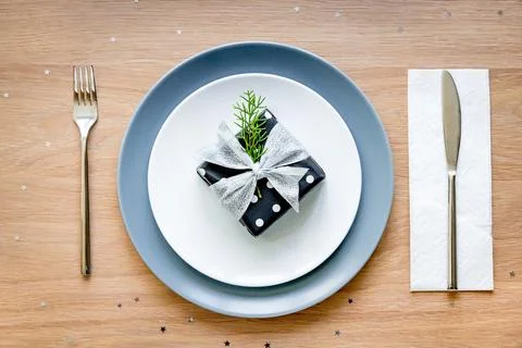 Top view of christmas table setting. A gift box in a plate. Stock Photos