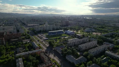 Top view of the city at sunset, visible road, cars, stadium and river Stock Footage 213988093