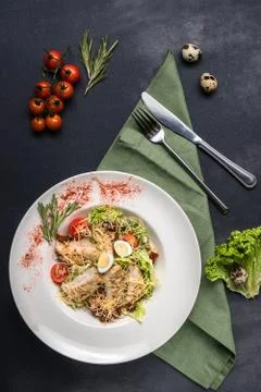 Top view on classic Caesar salad with grilled chicken breast and half of quai Stock Photos
