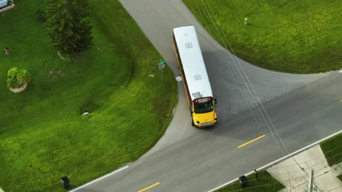 Top view of classical american yellow school bus driving on rural town street Stock Footage 219693122