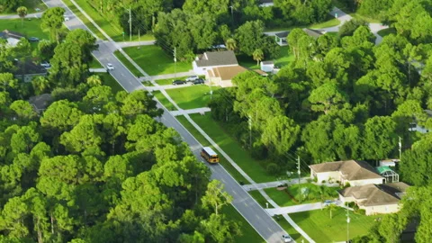 Top view of classical american yellow school bus driving on rural town street Stock Footage 223250695