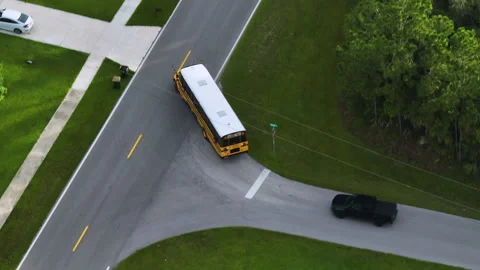 Top view of classical american yellow school bus driving on rural town street Stock Footage 229707338
