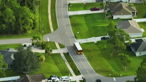 Top view of classical american yellow school bus driving on rural town street Stock Footage 231075642