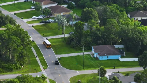 Top view of classical american yellow school bus driving on rural town street Stock Footage 232378453