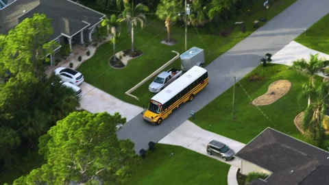 Top view of classical american yellow school bus driving on rural town street Stock Footage 233303650