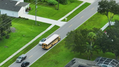 Top view of classical american yellow school bus driving on rural town street Stock Footage 234284298