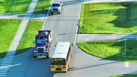 Top view of classical american yellow school bus driving on rural town street Stock Footage 235657378