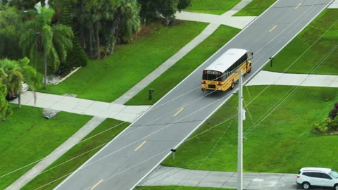 Top view of classical american yellow school bus driving on rural town street Stock Footage 242808288