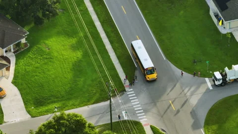 Top view of classical american yellow school bus driving on rural town street Stock Footage 263259542