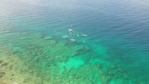 Top view of clear ocean turquoise water and a small cluster of boats with Stock Footage 233229476