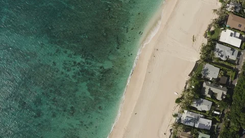 Top view of clear turquoise ocean and sand beach with houses and trees on coast Video stock 126611984