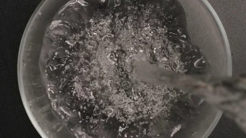 TOP VIEW: Clear water pours into a mixing bowl (slow motion) 스톡 동영상 72624136