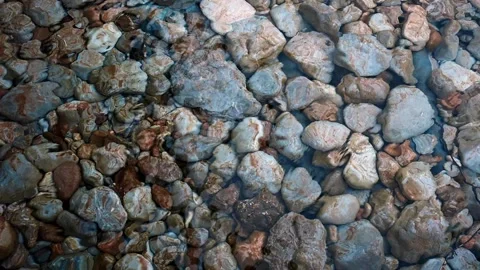 Top view of a clear wavy river with pebbles below.  Stock Footage 255604401