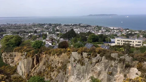 Top View of Cliff face and a Sea-Side Town From Hilltop In Killiney, Ireland Stock Footage 89976909
