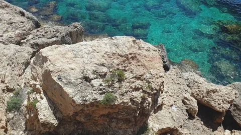 Top view from the cliffs to the turquoise clear sea, cliffs and rocks near beach 스톡 동영상 121262542