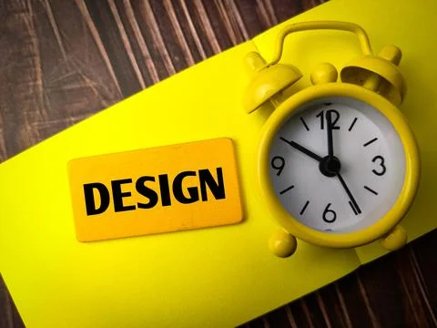Top view clock and colored notebook with text DESIGN Stock Photos