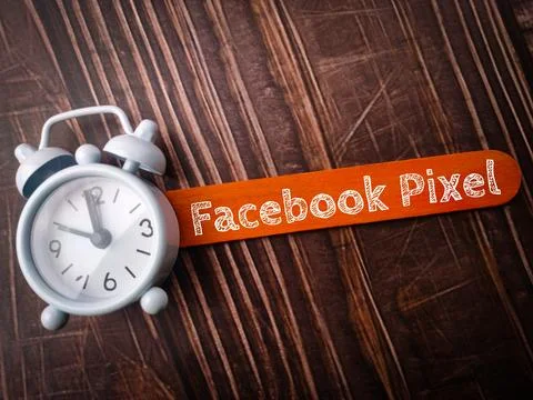 Top view clock and colored ice cream stick with text Facebook Pixel on wood.. Stock Photos