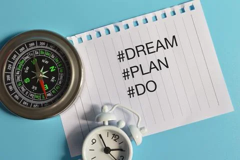 Top view of clock, compass and white paper written with hashtag DREAM, PLAN a Stock Photos
