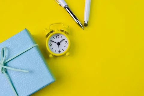Top view of clock, pen and gift box. Flat lay view. Copy space Stock Photos